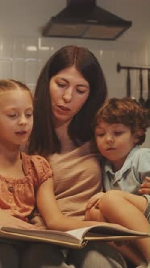 Mother Reads Book to Children Indoors