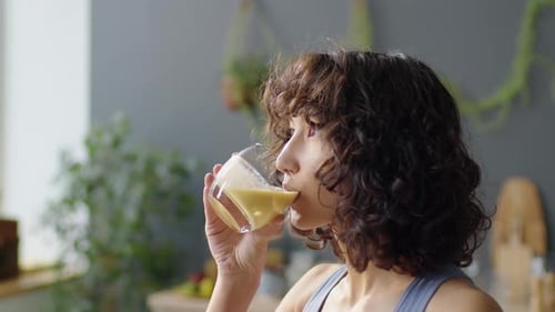 Young Woman Drinks Healthy Smoothie Indoors
