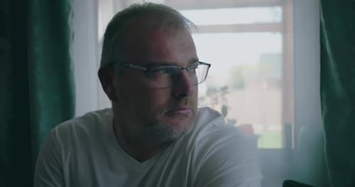 Man in Glasses Thoughtful and Pensive Indoors Near Window