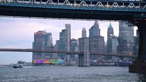 The Brooklyn Bridge from below the Manhattan Bridge. Boat moves by the river.