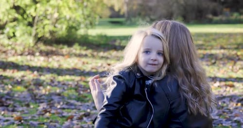 Mother and child daughter hugging and embracing at park