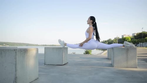 Woman Stretching Between Concrete Blocks in Splits