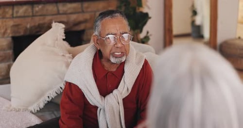 Senior Man Talking on Couch Indoors