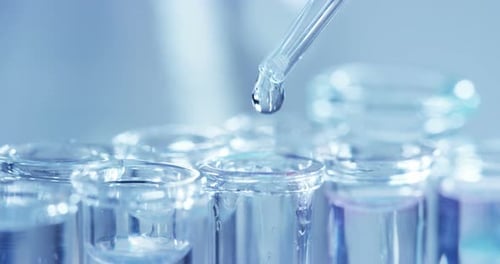 Dropper Adds Solution into Test Tubes in Lab