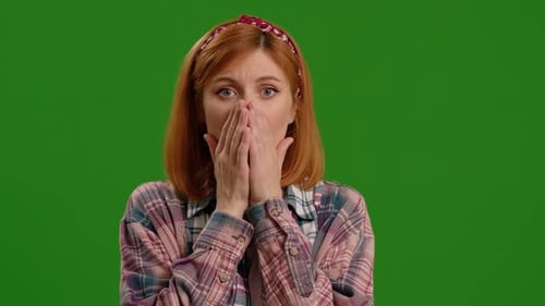 Young Woman Reacting to Shock with Hands Covering Mouth