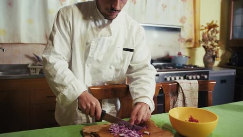 Chef Chopping Red Onions in Kitchen