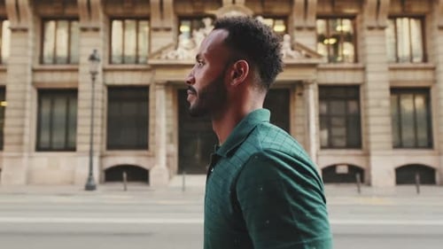Profile of young man walking down the street in the old town background