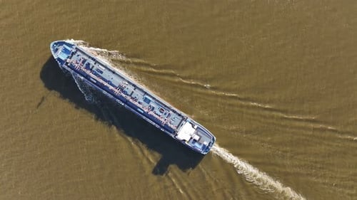 Birdseye view, tanker on river unfolds as powerful yet graceful vessel