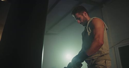 Boxer Puts on Boxing Gloves in Gym