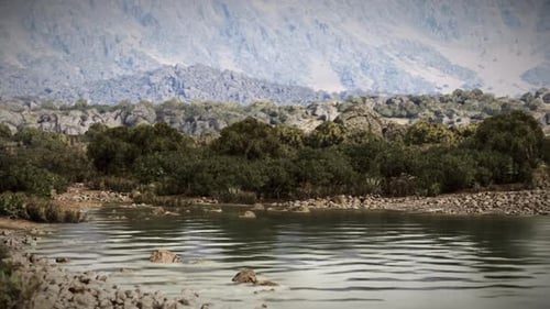 Ruhiger Fluss, der die Berge in einer ruhigen Landschaft bei Tageslicht widerspiegelt