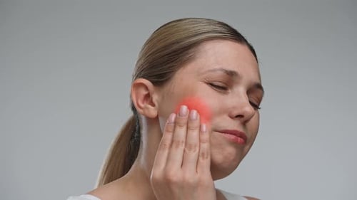 Woman Experiencing Dental Pain with Hand on Cheek
