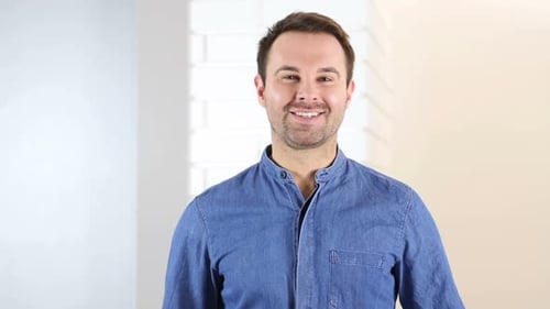 Cheerful Man Waving and Smiling at the Camera