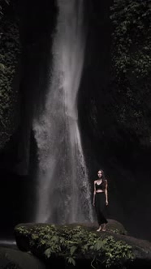 Woman by Tropical Waterfall in Lush Nature