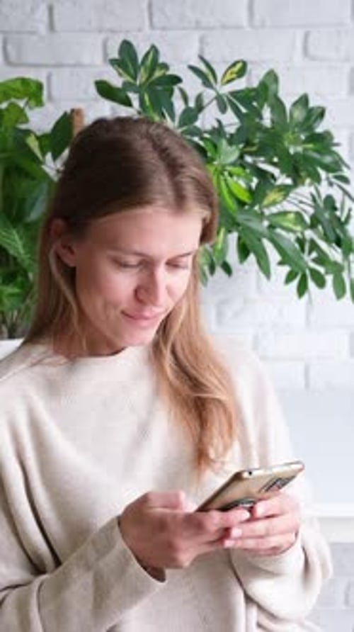 Young Woman Using Mobile Phone Indoors Portrait