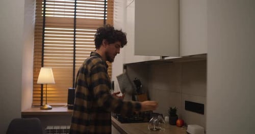 Young Man Prepares Tea in Modern Kitchen