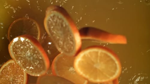 Orange Slices Splashing Into Juice