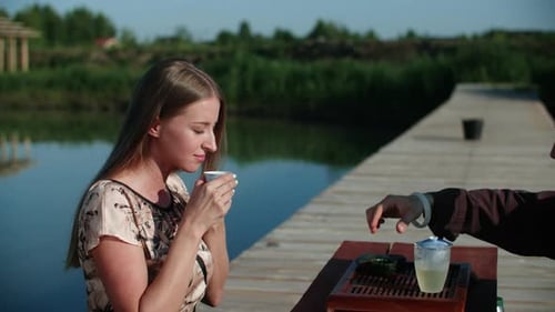 Young Woman Sniffing Testing Tea Sitting on River Wooden Pier on Tea Ceremony