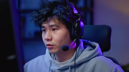 Closeup Asian Man Professional Gamer Playing Video Game on Computer During Esports Tournaments From
