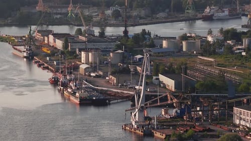 Industriekräne und Schiffe auf einer Werft in Riga während der Goldenen Stunde