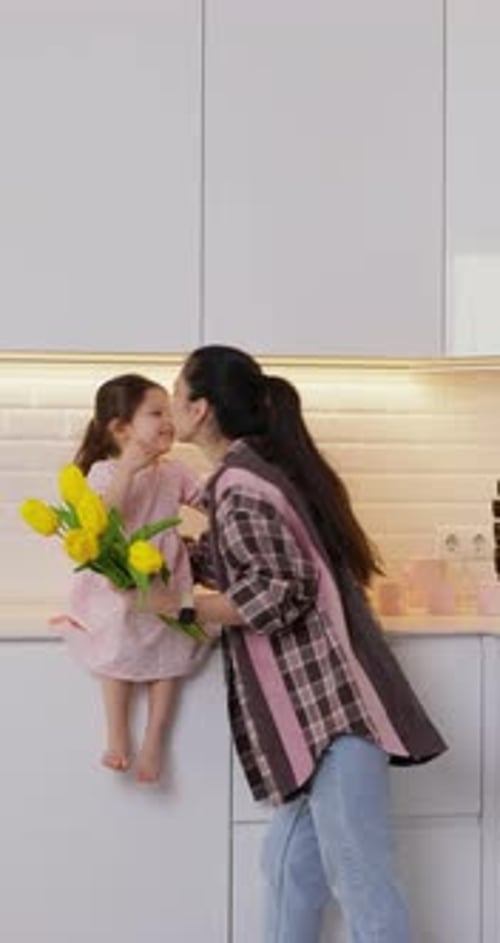 Loving Mother and Daughter Hug with Yellow Tulips