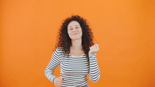 Happy Woman Dancing on Orange Background