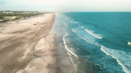 Drone aerial view of paradise beach. Turquoise sea water and clear sand at sunset.