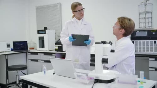Scientists at Work with Microscope and Laptop
