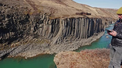 Man Using Drone Control At Edge Of Studlagil Canyon
