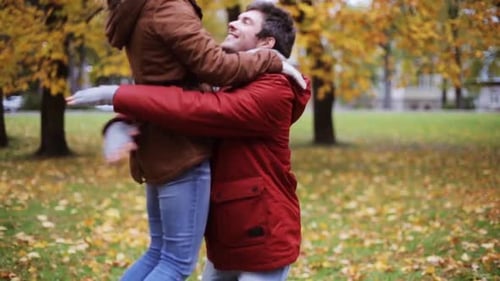 Happy young couple meeting and embracing in autumn park love and relationships