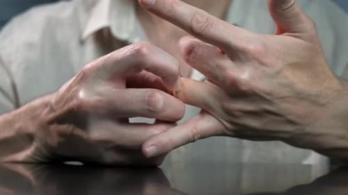 Besorgter trauriger Mann, der den Ring auszieht