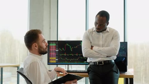 Deux traders de crypto-monnaies font une analyse professionnelle d'un graphique en chandeliers, créant une stratégie avec un stylo