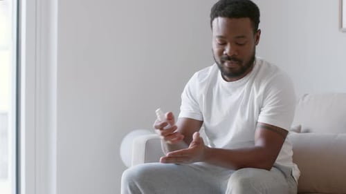 Man Applies Sanitizer to Hands for Hygiene