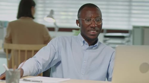 African American Businessman Web Conferencing on Laptop in Office