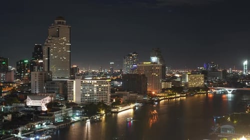 Bangkok Thailand Night Time Lapse. Boats in River Lights on Downtown Skyscrapers and Buildings