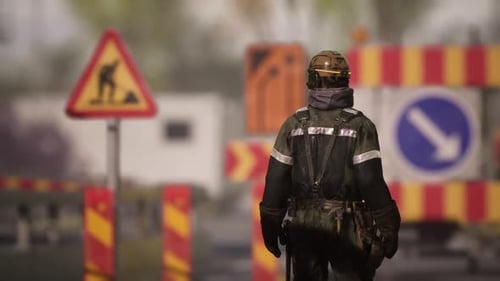 Worker Monitors Construction Site Safety Signs During the Day at a Work Zone