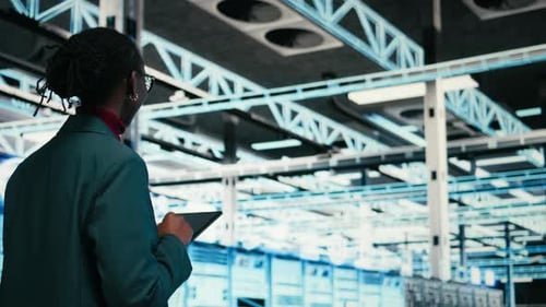 Data Center Programmer Writing Code for Resource Optimization Using Tablet