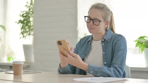Attractive Beautiful Young Woman Using Smartphone in Office