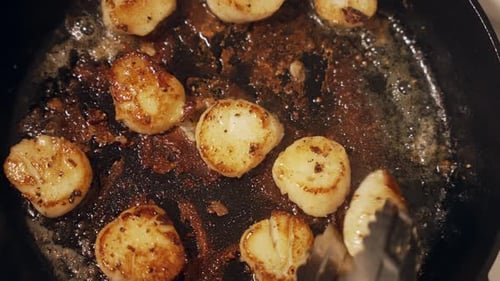 Topdown shot, Scallops being turned and browning on frying pan, Close up