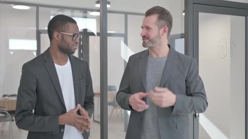 Businessmen Talking in an Office with Glass Wall