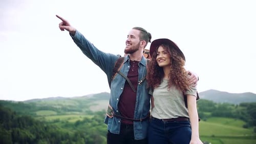 Couple Hiking on Mountain, Looking at View Together