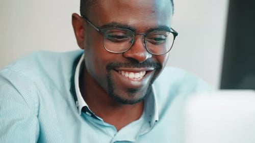 Happy African Man Works with Laptop