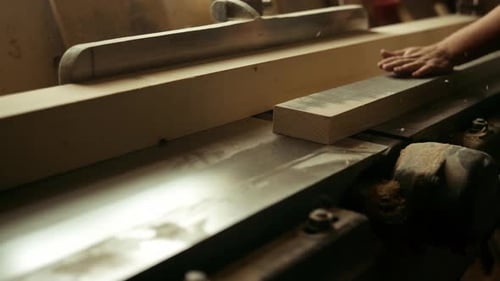 Unknown carpenter working on wood lathe machine in carpentry workshop studio