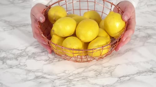 Step By Step Fresh Organic Lemons in a Wire Basket on a Marble Surface