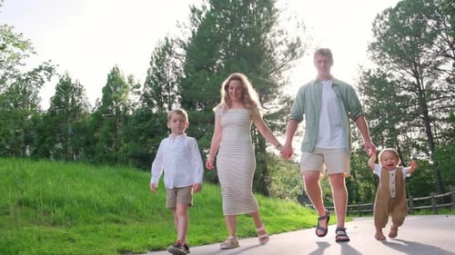 A Family Strolls Hand in Hand Through a Beautiful Park Enjoying Joy
