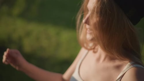 Smiling Woman Winking and Shielding Eyes from Sun