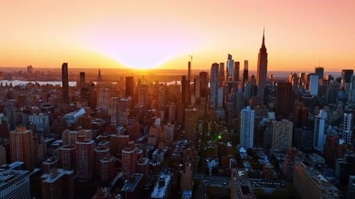 Sun setting over the horizon in modern New York city, US.