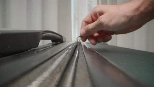 Dolly slider, close up. Fingers close the zipper of a suitcase, securing the contents in preparation