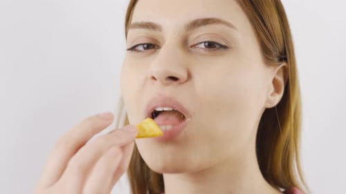 Close-up of woman eating chips.