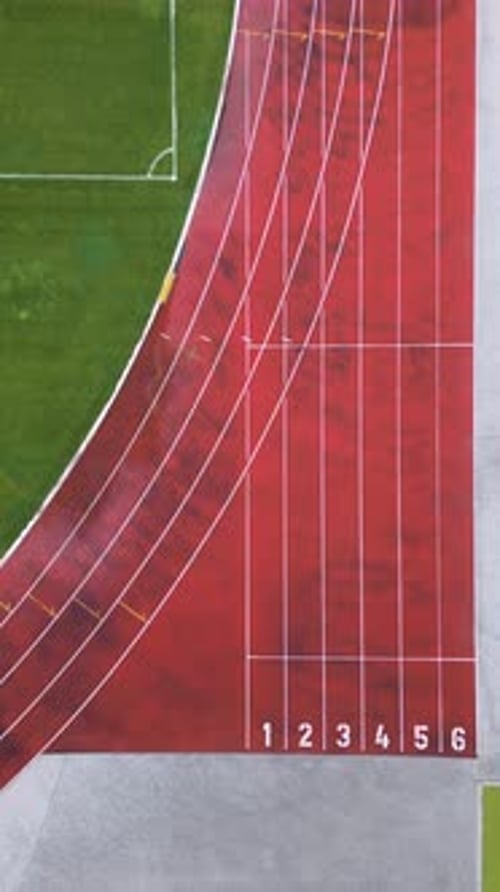 Aerial View of a Red Running Track with Marked Lanes and Curved Lines Athletic Stadium Section with