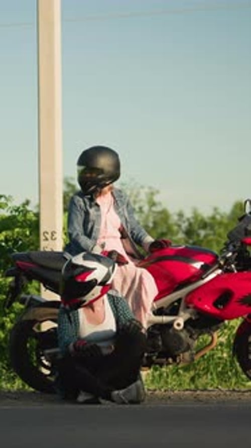 Two Women Resting By a Motorcycle on the Roadside Looking Left and Right